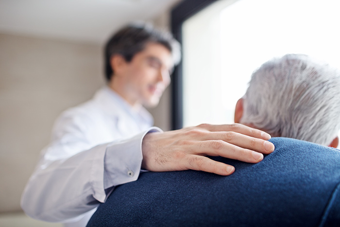 Doctor offering comfort to an elderly patient